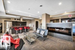 Open-concept space featuring a built-in kitchen area with stainless steel appliances and a breakfast bar - 