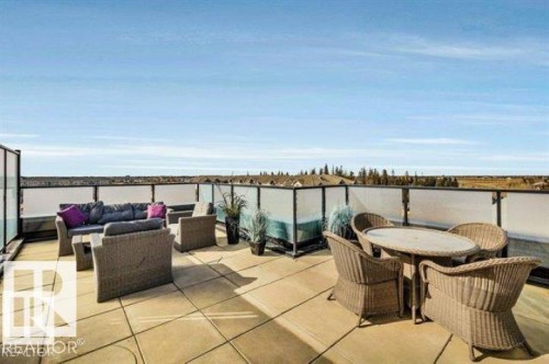 Expansive rooftop terrace featuring large format pavers and a contemporary glass and metal railing system - 607 11080 Ellerslie Road, Edmonton, AB - Outdoor