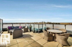 Expansive rooftop terrace featuring large format pavers and a contemporary glass and metal railing system - 
