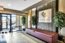 Lobby entrance featuring large glass doors, tile flooring, a built-in upholstered bench, a decorative accent wall, and recessed lighting - 607 11080 Ellerslie Road, Edmonton, AB  - Indoor Photo Showing Other Room 
