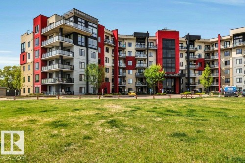 Contemporary multi-story building featuring a facade of red, black, and beige panels - 607 11080 Ellerslie Road, Edmonton, AB - Outdoor With Balcony With Facade