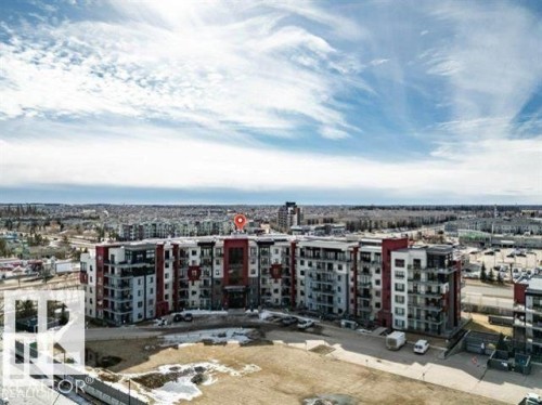 Multi-story residential building featuring a contemporary design with red and gray facade accents - 607 11080 Ellerslie Road, Edmonton, AB - Outdoor With View