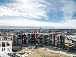 Multi-story residential building featuring a contemporary design with red and gray facade accents - 