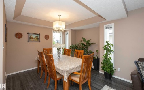Recessed ceiling design with a central chandelier, dark wood-finish flooring, and neutral wall tones - 10739 109 Avenue, Westlock, AB 