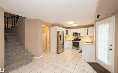 Modern kitchen featuring white cabinetry, stainless steel appliances, and a tile backsplash - 10739 109 Avenue, Westlock, AB 