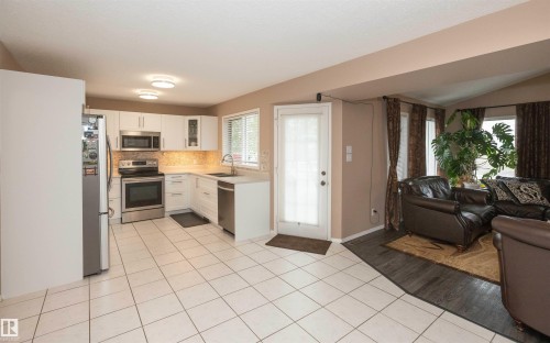 Bright kitchen featuring white cabinetry, stainless steel appliances, and a tiled backsplash - 10739 109 Avenue, Westlock, AB 