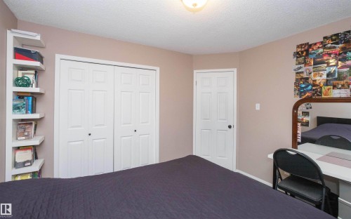 Interior room featuring neutral wall paint, a built-in corner shelving unit, and a two-panel bifold closet door - 10739 109 Avenue, Westlock, AB 