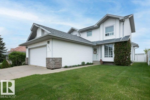 Two-story residence featuring white siding and a prominent two-car garage with brick accents - 10739 109 Avenue, Westlock, AB 