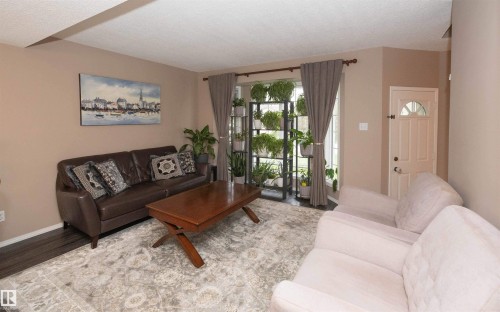 Living area with dark wood-finish flooring and neutral wall tones - 10739 109 Avenue, Westlock, AB 