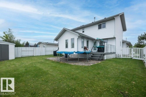 Rear exterior featuring white vinyl siding and a multi-level deck with white railings - 10739 109 Avenue, Westlock, AB 