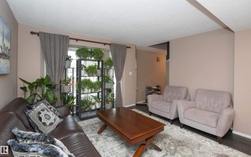 Living area featuring neutral wall tones, window treatments, and dark wood-finish flooring - 10739 109 Avenue, Westlock, AB 