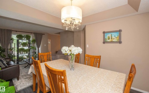 Dining area featuring a contemporary chandelier with crystal accents, recessed ceiling details, and neutral wall tones - 10739 109 Avenue, Westlock, AB 