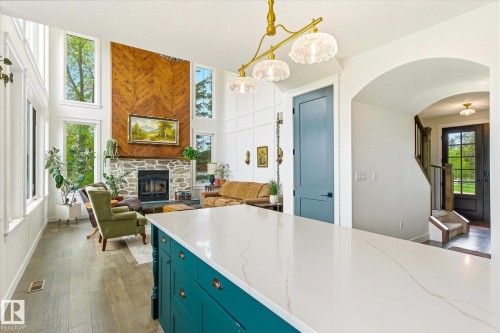 Kitchen island featuring a white countertop with subtle veining and teal cabinetry - 59102 Rge Road 234, Rural Westlock County, AB 