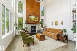 Two-story living area featuring a stone fireplace with a herringbone wood-finish accent wall - 