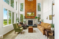 Two-story living room featuring a stone fireplace with a wood-finish herringbone accent wall - 