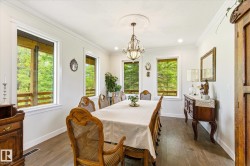 Bright dining area featuring wood-finish flooring, white trim, and multiple large windows - 