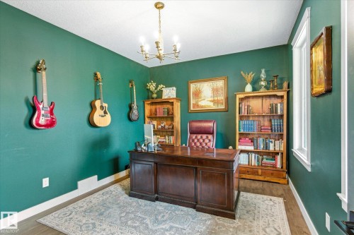 Dedicated office space featuring rich green walls, wood-finish flooring, and a decorative area rug - 59102 Rge Road 234, Rural Westlock County, AB 