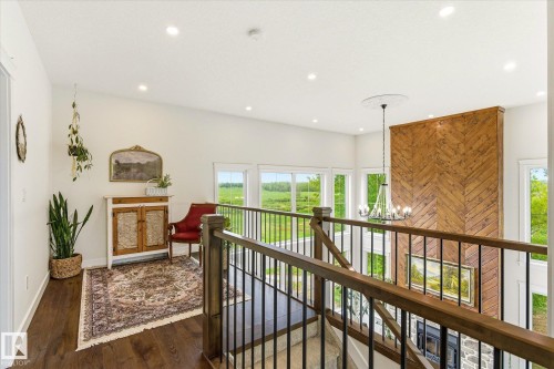 Upper-level hallway featuring wood-finish flooring, recessed lighting, and a wood and metal railing system - 59102 Rge Road 234, Rural Westlock County, AB 