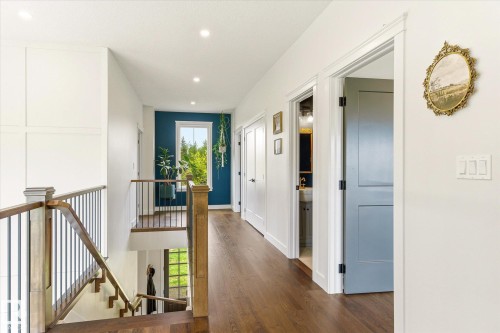 Hallway featuring wood-finish flooring, recessed lighting, white trim, and a prominent window with a bold accent wall - 59102 Rge Road 234, Rural Westlock County, AB 