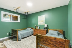 Bedroom featuring a window, wood-finish flooring, two wood bed frames, and a wood dresser - 