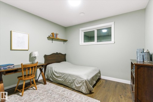 Room featuring light green walls, wood-finish flooring, white trim, and a window with white framing - 59102 Rge Road 234, Rural Westlock County, AB 