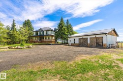 Two-story residence featuring a multi-gable roofline, covered porch, and a gravel driveway - 