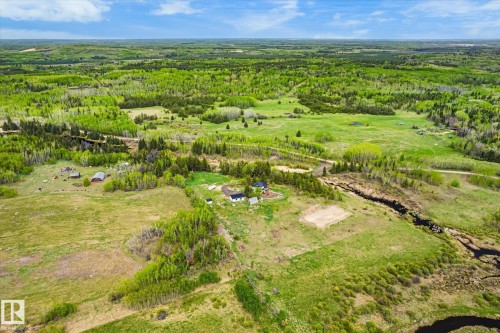 Expansive land parcel featuring a winding creek, varied tree coverage, open fields, and multiple structures - 59102 Rge Road 234, Rural Westlock County, AB 