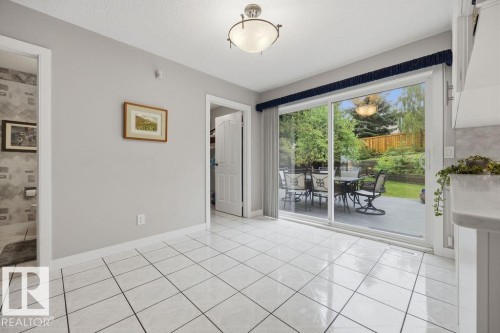Ceramic tile flooring extending to a sliding newer patio door leading to the huge 2-tier deck and the beautifully landscaped yard - 31 Wentworth Crescent, St. Albert, AB - Indoor Photo Showing Other Room