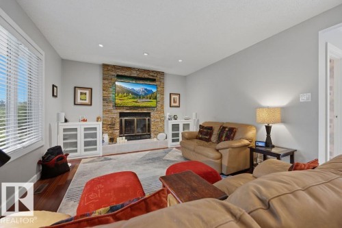 Living area featuring a stone-clad fireplace and hearth - 31 Wentworth Crescent, St. Albert, AB - Indoor Photo Showing Living Room With Fireplace