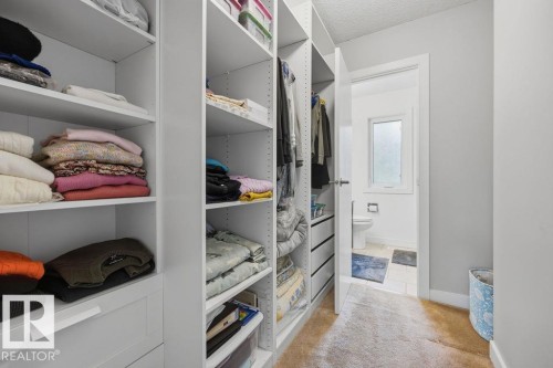 Custom closet organization system with adjustable shelving, built-in drawers, and clothing rods - 31 Wentworth Crescent, St. Albert, AB - Indoor With Storage