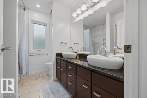 Renovated (2023) 5-pce main bath of the upper level featuring a large vanity with double sinks, marble tops and loads of storage. There is a lovely designer tile surround and ceramic tile flooring. - 31 Wentworth Crescent, St. Albert, AB - Indoor Photo Showing Bathroom