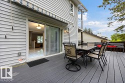 Expansive outdoor 2-tier deck featuring newer composite decking and a retractable awning - 