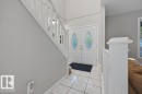 Entryway featuring double doors with decorative glass inserts, ceramic tile flooring and a contemporary white staircase with matching balusters - 31 Wentworth Crescent, St. Albert, AB  - Indoor Photo Showing Other Room 