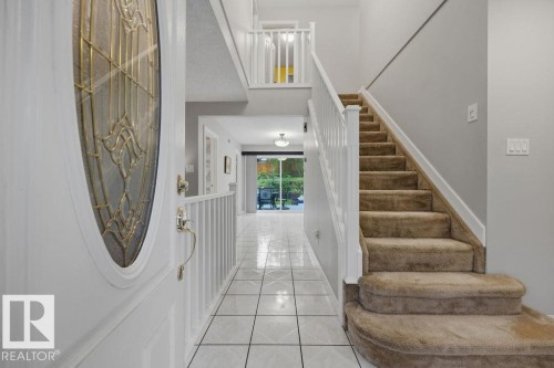 Entryway featuring a decorative glass door, tiled flooring and carpeted staircase - 31 Wentworth Crescent, St. Albert, AB - Indoor Photo Showing Other Room