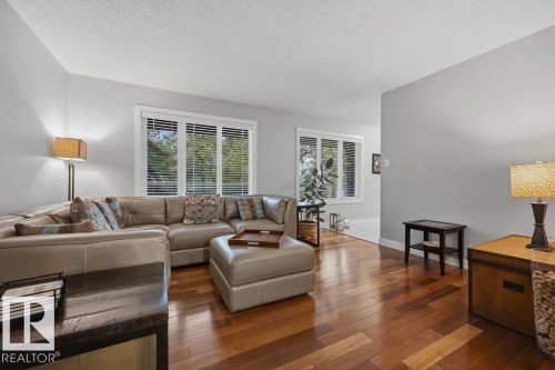 Spacious living area featuring rich hardwood flooring and ample natural light from multiple windows with blinds - 31 Wentworth Crescent, St. Albert, AB - Indoor Photo Showing Living Room