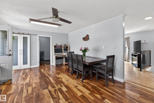 Warm wood-finish flooring extending through the dining area and beyond - 110 52308 Rr 214, Rural Strathcona County, AB 