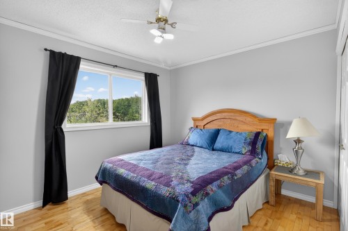Hardwood flooring extends throughout this room, complemented by a large window with white trim - 110 52308 Rr 214, Rural Strathcona County, AB 