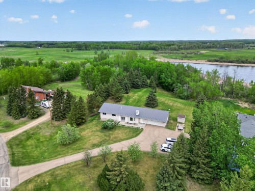Ranch-style residence featuring a prominent metal roof, attached two-car garage, and a gravel driveway - 110 52308 Rr 214, Rural Strathcona County, AB 