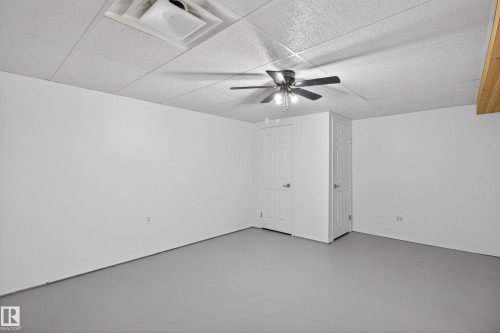 Interior room featuring a ceiling fan, white walls, and light gray flooring - 110 52308 Rr 214, Rural Strathcona County, AB 