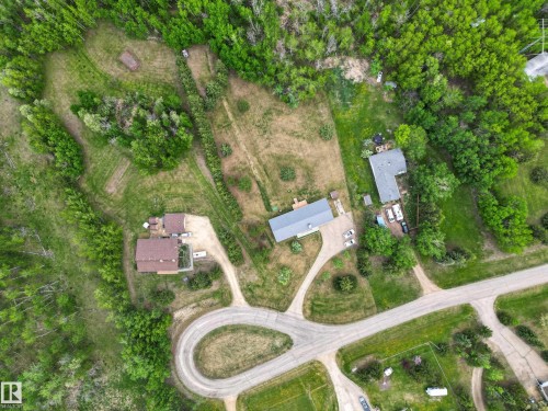Aerial perspective showcasing multiple properties amidst extensive green landscaping - 110 52308 Rr 214, Rural Strathcona County, AB 