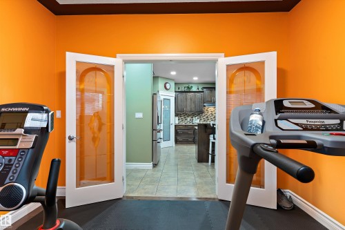 Double French doors with frosted glass panels open to a tiled floor entryway - 16609 58A Street, Edmonton, AB 