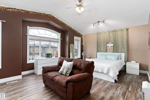 Spacious room featuring wood-finish flooring and a vaulted ceiling with a ceiling fan - 16609 58A Street, Edmonton, AB 