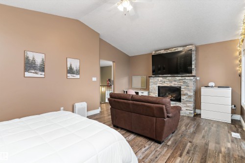 Living area featuring wood-finish flooring and a vaulted ceiling - 16609 58A Street, Edmonton, AB 
