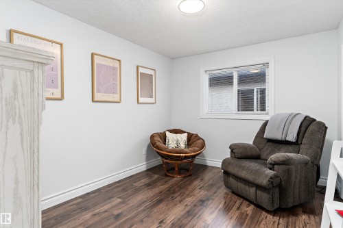 Interior room featuring wood-finish flooring, white baseboards, and a single window with blinds - 16609 58A Street, Edmonton, AB 
