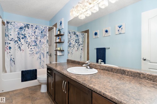 Bathroom featuring a full vanity with a built-in sink, an overhead light fixture, a shower-tub combination, and tiled flooring - 16609 58A Street, Edmonton, AB 