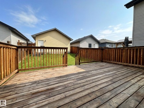 Expansive wooden deck featuring sturdy railings and a clear sightline to the grassy yard - 9432 211 Street, Edmonton, AB 