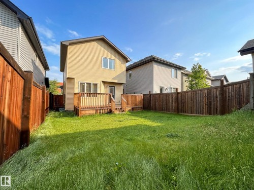 Spacious backyard featuring a two-tiered wooden deck, full-height privacy fencing, and ample green space - 9432 211 Street, Edmonton, AB 