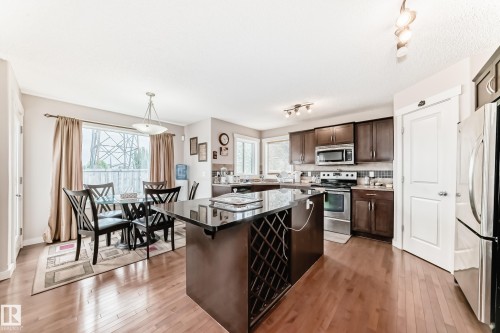 Open-concept kitchen and dining area with wood-finish flooring - 2808 36 Avenue, Edmonton, AB 