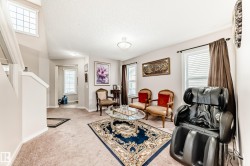 Spacious living area featuring carpet flooring, multiple windows with blinds, and recessed lighting - 