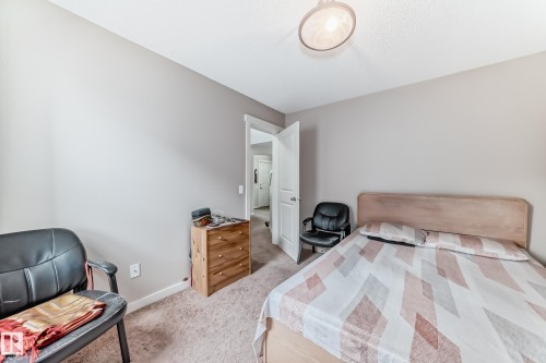 Neutral-toned bedroom with textured carpeting and a ceiling-mounted light fixture - 2808 36 Avenue, Edmonton, AB 